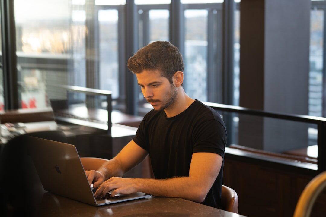 Belgian office employee reading a suspicious email on a laptop